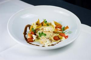 a white plate of food on a table at Hotel Das Zeit in Lenzing