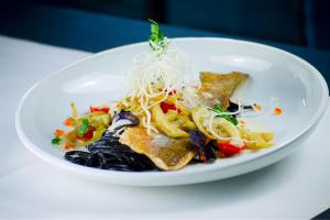 a plate of food with pasta and vegetables on a table at Hotel Das Zeit in Lenzing