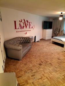 ein Wohnzimmer mit einem Sofa und einem TV in der Unterkunft Red appartament in Bagnolo Piemonte