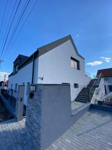 una casa blanca con una escalera delante en Villa Corner, en Tihany