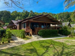 a house with a porch and a lawn at Koh Yao Seaview Bungalow in Ko Yao Noi
