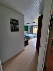 1 dormitorio con 1 cama y una pintura en la pared en Casa Klos - Quartos amplos en Curitiba