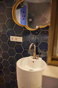 a bathroom with a sink and a mirror at Boutique Hotel de Drentse Liefde in Dwingeloo