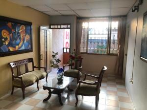 a living room with two chairs and a table and a couch at Hotel Los Corales Tulua in Tuluá