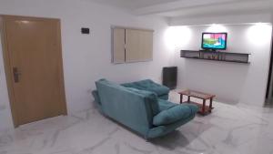 uma sala de estar com um sofá azul e uma televisão em El Bambino em Puerto Madryn