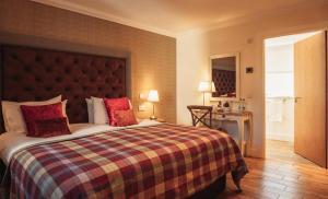 um quarto com uma cama grande e almofadas vermelhas em The Bowmore Lodge em Bowmore