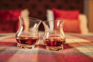 due bicchieri di whisky seduti su un tavolo di The Bowmore Lodge a Bowmore