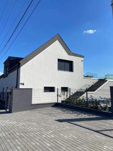 a white building with steps and a fence at Villa Corner in Tihany