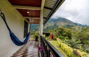 a balcony with a hammock on the side of a house at Estancia Rosa de Jericó Campestre in Guaduas