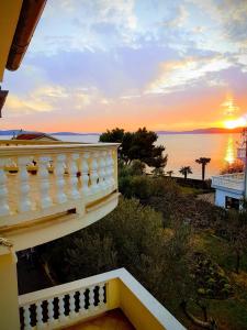 un balcone di una casa con un tramonto sullo sfondo di Apartments Sandra a Sukošan (San Cassiano)