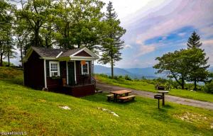 una piccola casa su una collina con tavolo da picnic di The Lodge @ America’s Switzerland a North Adams