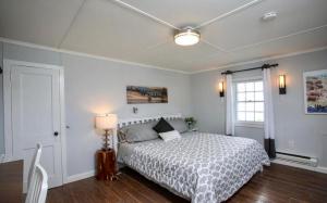 ein Schlafzimmer mit einem Bett, einer Lampe und einem Fenster in der Unterkunft The Lodge @ America’s Switzerland in North Adams