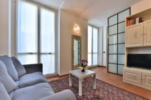 a living room with a couch and a tv at PONTACCIO22 APARTMENT- BRERA CENTRO STORICO in Milan