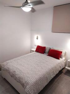 a bedroom with a bed with two red pillows on it at Modern 1 bed Apartment Cristianos in Arona