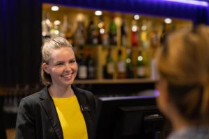 
a woman standing in front of a bar at Dockyard Hotel in Gothenburg
