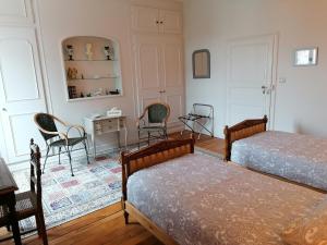 1 dormitorio con 2 camas, escritorio y sillas en Au Puy Des Vérités en Lapalisse