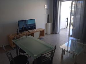 a living room with a tv and a table with a television at Modern 1 bed Apartment Cristianos in Arona