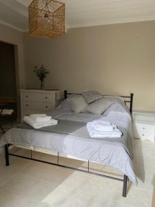 a bed with towels on it in a bedroom at Pepper Tree in Egina