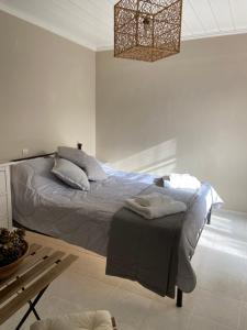 a bedroom with a bed and a chandelier at Pepper Tree in Egina