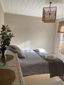 a bedroom with a bed and a potted plant at Pepper Tree in Egina