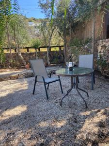 two chairs and a table and a table and a table and chair at Pepper Tree in Egina