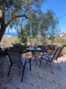 a table and two chairs and a table and a tree at Pepper Tree in Egina