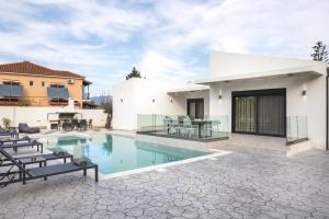a villa with a swimming pool and a patio at Villa De Reve in Laganas