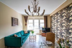 a living room with a blue couch and a table at Apartamenty Gdynia City Center in Gdynia