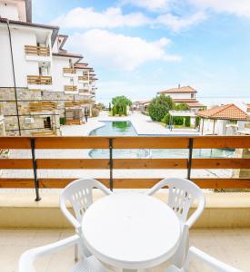 Biały stół i krzesła na balkonie w obiekcie Robinson Beach Apartments w Elenite
