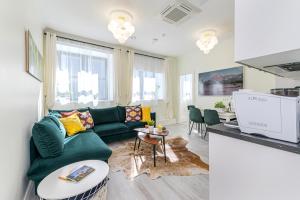 a living room with a green couch and a table at Tallinn City Harbour Apartments in Tallinn