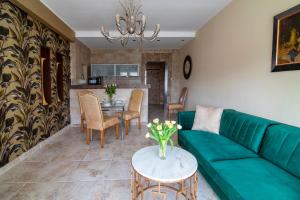 格地尼亞的住宿－格丁尼亞市中心公寓，客厅配有绿色沙发和桌子