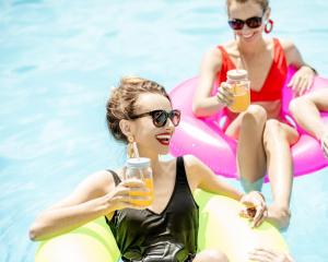 a group of women in the swimming pool drinking beer at Topazio Vibe Beach Hotel & Apartments - Adults Friendly in Albufeira