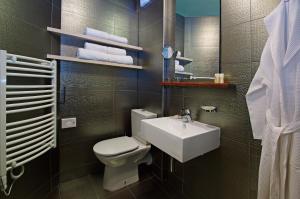 a bathroom with a white toilet and a sink at Boutique Hotel Bol in Bol
