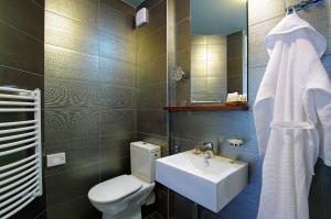a bathroom with a toilet and a sink and a mirror at Boutique Hotel Bol in Bol