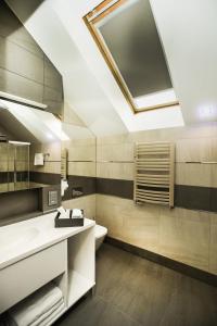 a bathroom with a sink and a toilet and a skylight at Hotel Inter in Bielany Wrocławskie