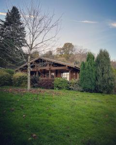 a wooden house in a field with a tree at Countryside Log Cabin With Hot Tub - Beech in Leominster