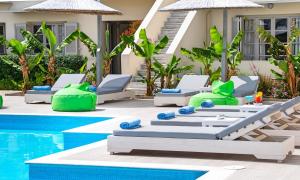 a resort pool with lounge chairs and a swimming pool at Elounda Garden Suites Heated Pool in Elounda