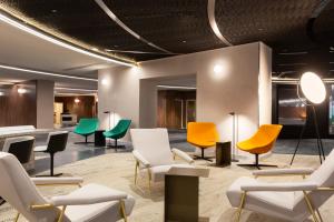 a waiting room with colorful chairs and tables at Pullman Paris Montparnasse in Paris
