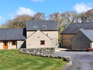 a large stone house with a garage at Fodol Cottages in Menai Bridge