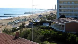 - une vue sur la plage avec un bâtiment et l'océan dans l'établissement Hotel Condor, à Lido di Jesolo