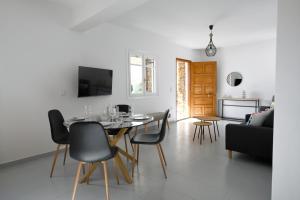 ein Esszimmer und ein Wohnzimmer mit einem Tisch und Stühlen in der Unterkunft Vourkari, modern apartment overlooking the Marina of Vourkari in Ioulis