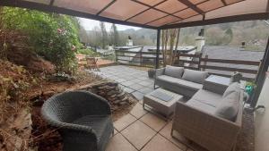 a patio with a couch and chairs on a patio at Ty Gwyn Cottage & Hot Tub in Betws-y-coed