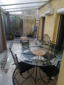 a glass table and chairs on a balcony at À 10min de la Croisette, bas de Villa Piscine Chauffée in Le Cannet