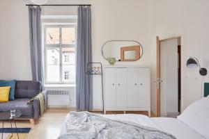 a bedroom with a bed and a couch and a window at Renovated Flat in Old Town Square by Prague Days in Prague