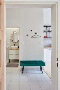 a white bathroom with a green bench in a room at Renovated Flat in Old Town Square by Prague Days in Prague