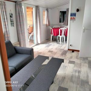 a living room with a couch and a table at Chalet mobil-home in Pénestin