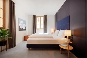 Pokój hotelowy z dużym łóżkiem i lampą w obiekcie Goldengel Design - Suiten im historischen Ortskern von Kaltern w mieście Caldaro