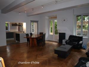 a living room with a table and a kitchen at Calme et Volupté in Maxilly-sur-Saône
