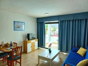 uma sala de estar com um sofá azul e uma mesa em Apartamento El Cardenal em Playa del Cura