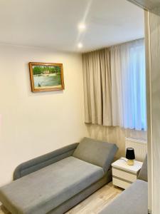 sala de estar con sofá y ventana en Apartamenty u Lucyny i Lecha, en Łukęcin